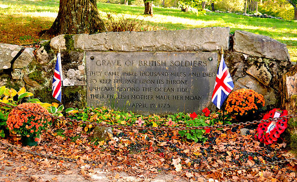 Grave of Unknown British Soldiers in Autumn The grave of three unknown British soldiers from the Revolutionary War at North Bridge in Concord, MA. Adorned with British flags, and surrounded by fall foliage and decoration, this stands as a proper acknowledgement of their sacrifice. concord massachusetts stock pictures, royalty-free photos & images