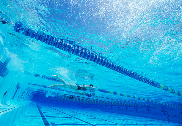 istock Swimmers racing together in swimming pool 465177549