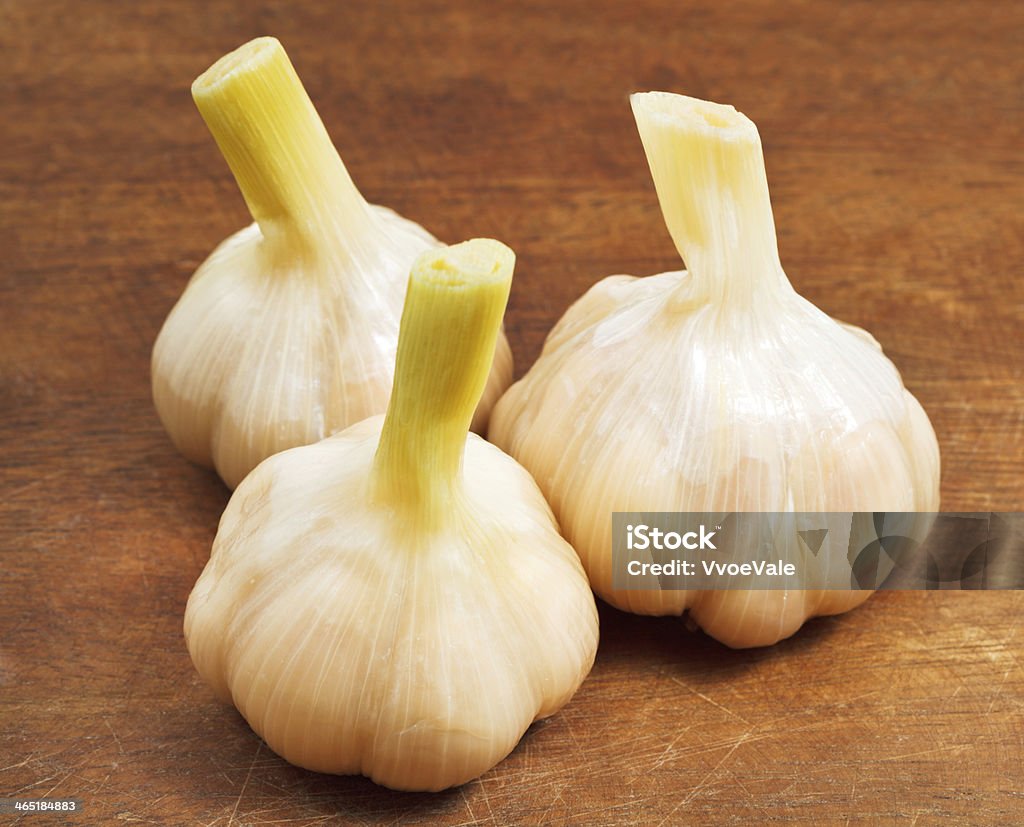 pickled garlic on wooden board three bulbs of pickled garlic on wooden board close up Appetizer Stock Photo