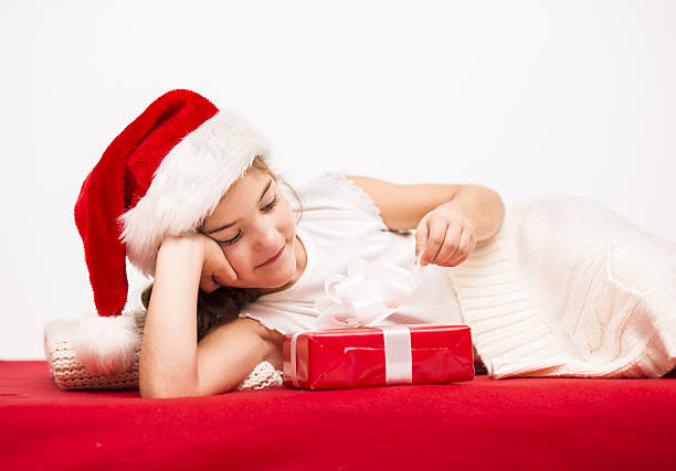 istock Small girl in santa hat with christmas gift 465185285