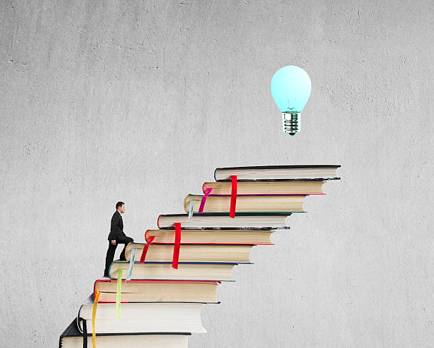 istock Businessman climbing on stack of books to reach bulb 465190721