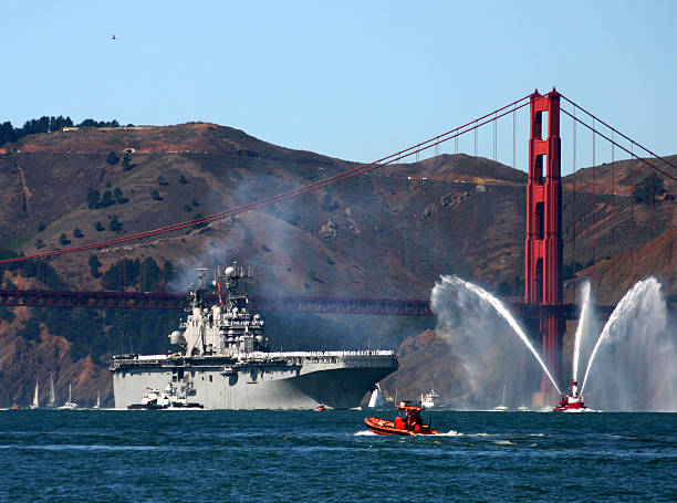 авианосец под мост золотые ворота - fire boat стоковые фото и изображения