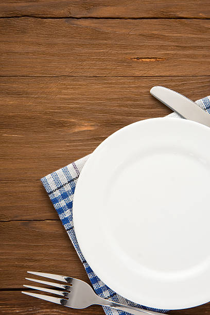 istock white plate, knife and fork on wood 465205917