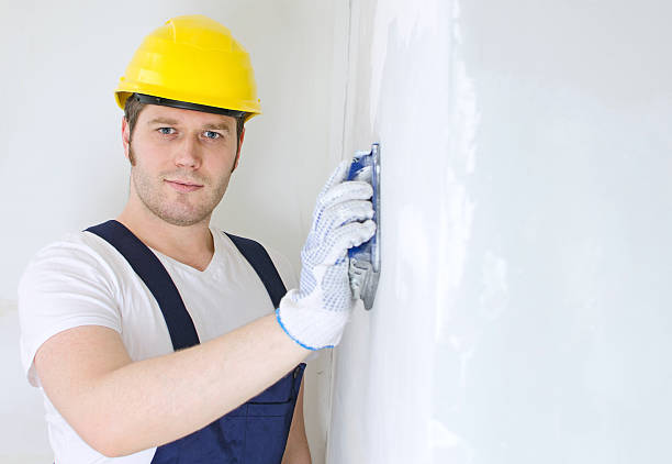 istock Male plasterer in hard hat polishing the wall. 465211241