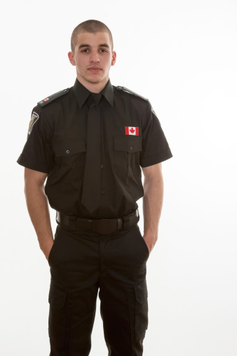 Police student in uniform standing over a white background. Canadian teenager in college studing to serve and protect