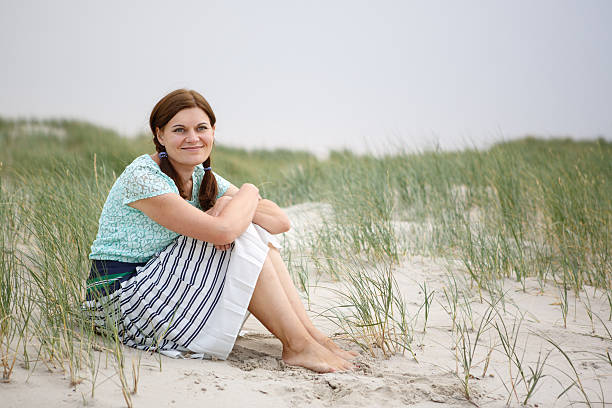 istock Young happy girl relaxing on sand dunes 465217369