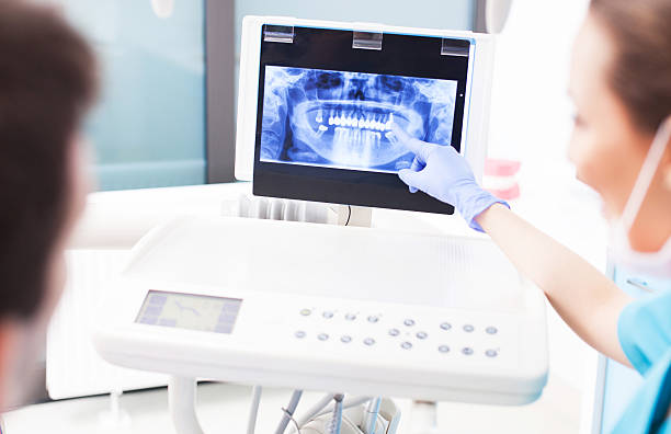 istock Dentist explaining x ray picture to patient 465217799