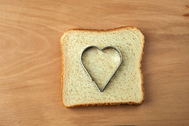 istock Slice of bread with cut out heart shape 465218117