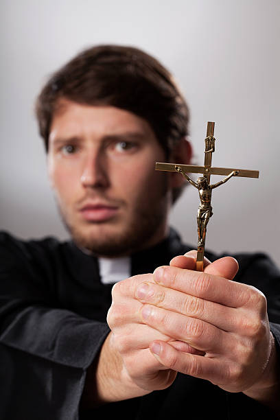 Exorcist with crucifix Exorcist holding a crucifix and making his prayers exorcism stock pictures, royalty-free photos & images