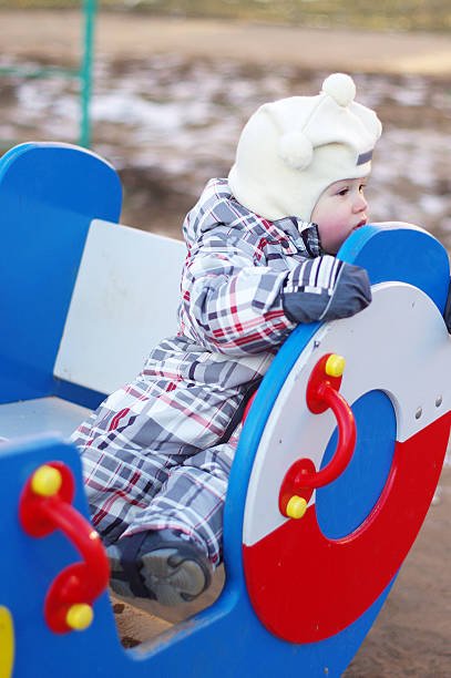istock sad baby sitting on playground 465221845