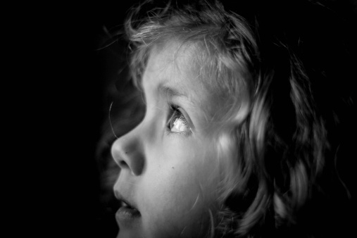 Close up of little girl looking up in black and white.