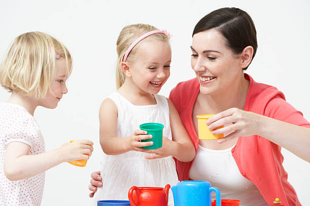 antes de la escuela, niños disfrutando de tea party con maestro - tea party little girls teapot child fotografías e imágenes de stock