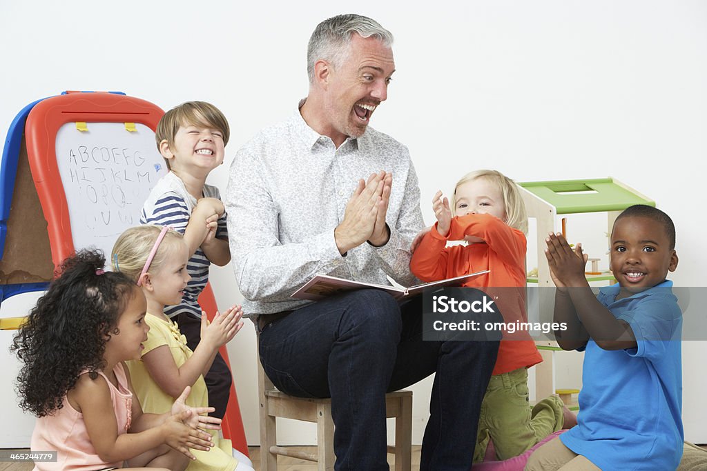 Pre School Teacher Reading Story To Children And Praying Pre School Teacher Reading Story To Excited Happy Children And Praying Teacher Stock Photo