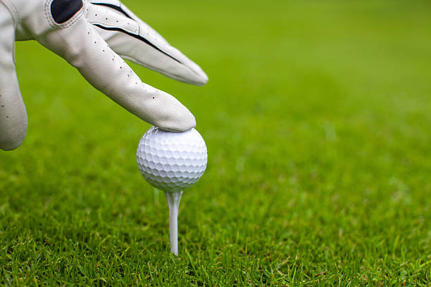 istock Hand placing golf-ball on tee over golf course 465245383