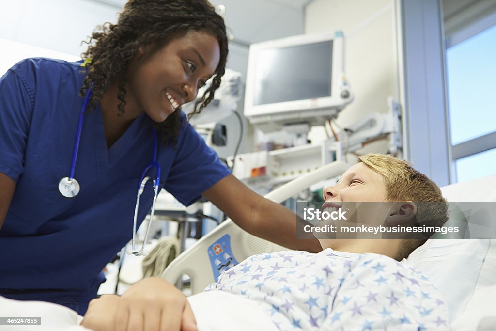 Boy Talking To Female Nurse In Emergency Room Boy Talking To Female Nurse In Brightly Lit Emergency Room Nurse Stock Photo