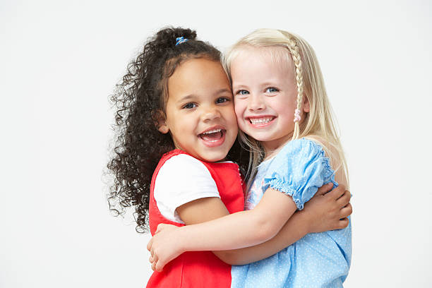 zwei mädchen umarmen vor der schule, andere - preschooler stock-fotos und bilder