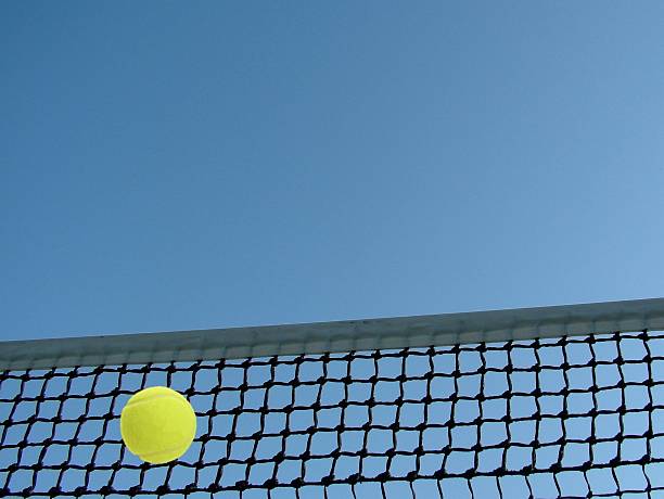 istock Tennis ball flying to net  on blue sky background. 465250857