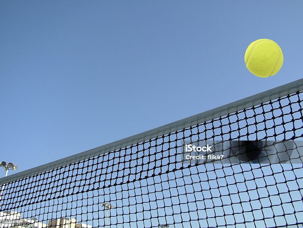 Tenis Piłka na netto latający na niebieski niebo w tle. - Zbiór zdjęć royalty-free (Piłka do tenisa)