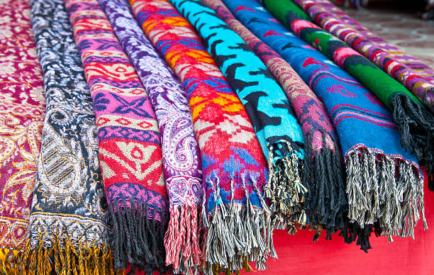 Pile of gentle folded shawls (scarfs) at the market, Nepal. Pile of gentle folded shawls (scarfs) at the market, Pokhara, Nepal. pashmina stock pictures, royalty-free photos & images