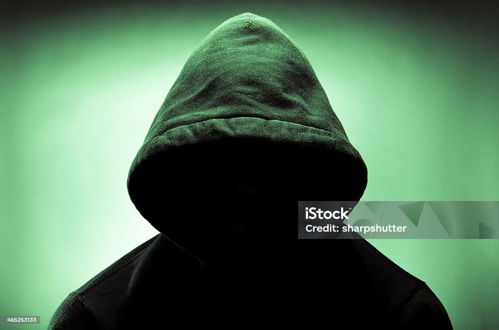 Hooded man with face in shadow image of a hooded man with his face in shadow Hiding Stock Photo