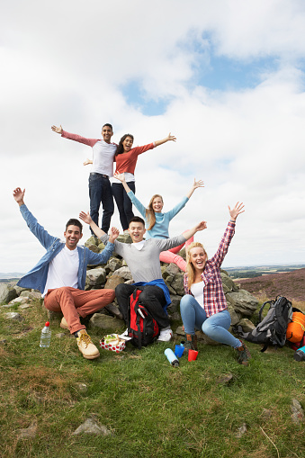 Group Of Young People Hiking In Countryside Smiling At Camera