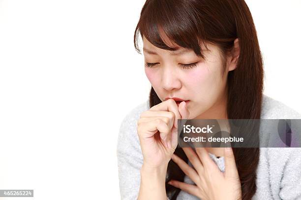 Young Japanese Woman Coughing And Covering Her Mouth Stock Photo - Download Image Now