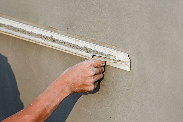 istock plasterer concrete worker at wall of house construction 465265544