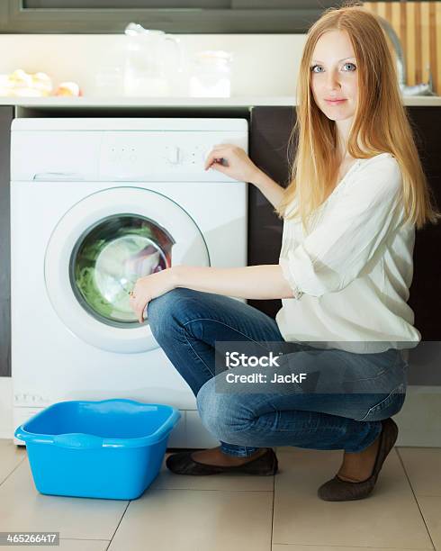 Blonde Woman Using Washing Machine At Home Stock Photo - Download Image Now - 20-29 Years, 25-29 Years, Adult