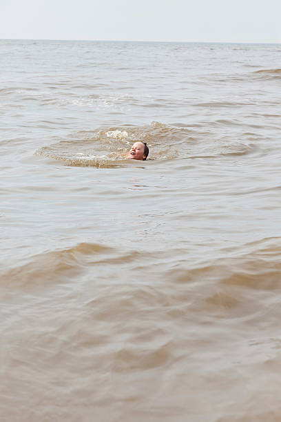 istock Kid boy having fun in the ocean with waves. 465267641