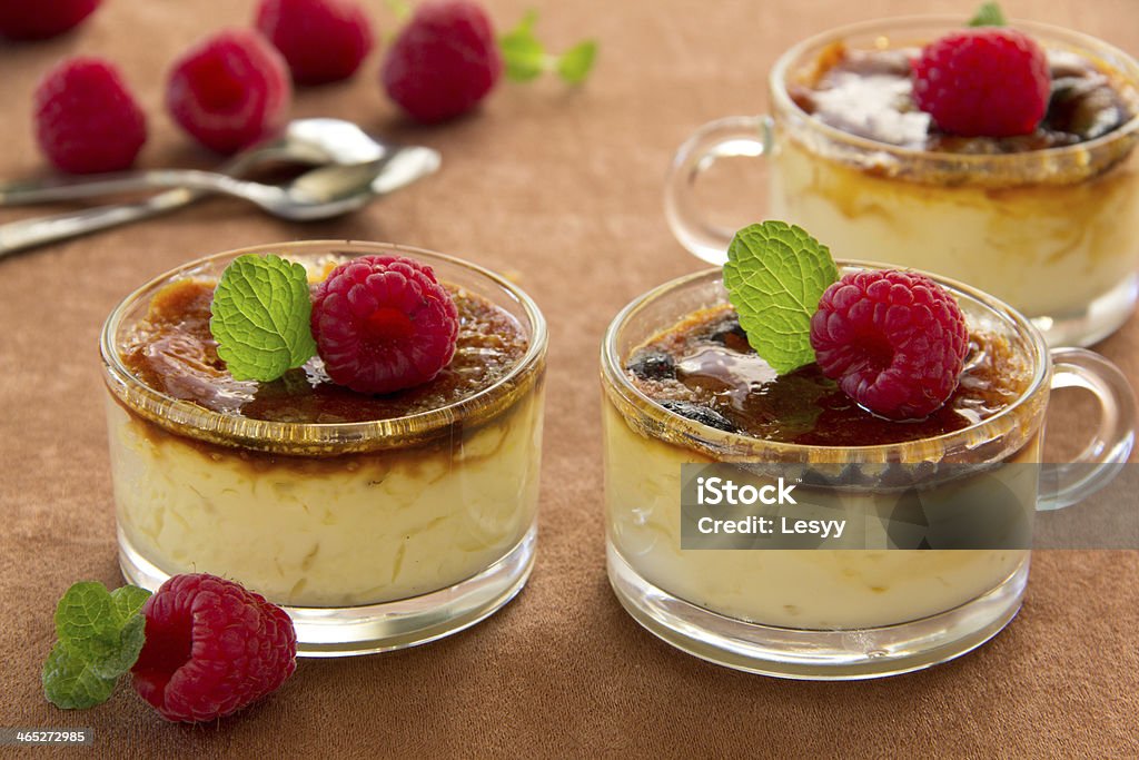 Creme bruleewith raspberries and mint. Creme brulee (cream brulee, burnt cream) with raspberries and mint. Baked Stock Photo