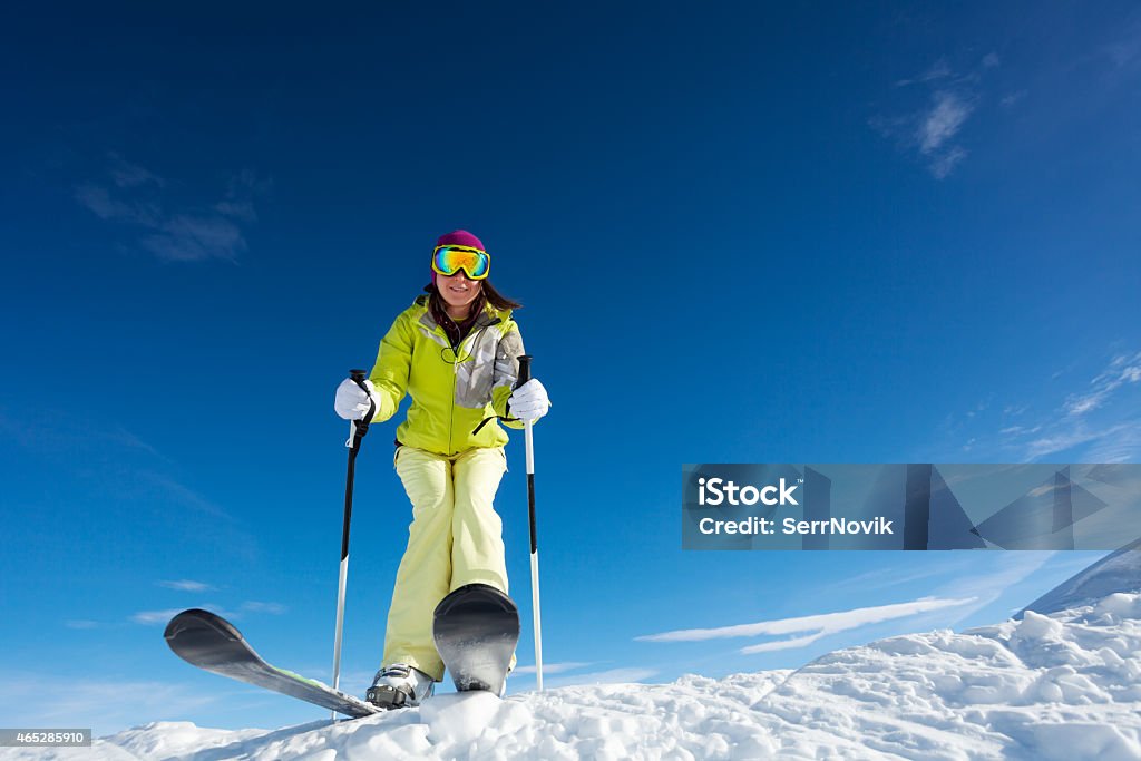 View from below of woman in mask holding poles View from below of happy woman in mask  holding ski poles and ready to ski at Krasnaya polyana ski resort and Caucasus mountains in Sochi, Russia 2015 Stock Photo