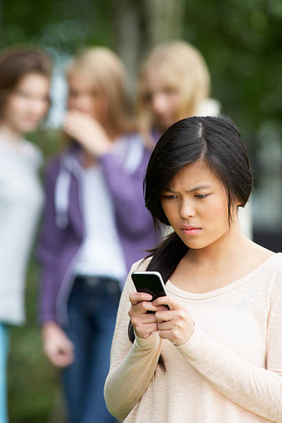 bullied ている 10 代の少女のテキストメッセージを携帯電話 - text messaging mobile phone teenagers only people ストックフォトと画像