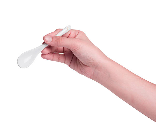 istock Hand holding white spoon isolated on white Background 465286940