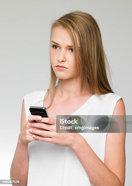 Teenage Girl Being Bullied By Text Message On Mobile Phone Stock Photo - Download Image Now