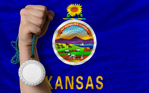 Silver medal for sport and flag of kansas Holding silver medal for sport and flag of us state of kansas kansas football stock pictures, royalty-free photos & images