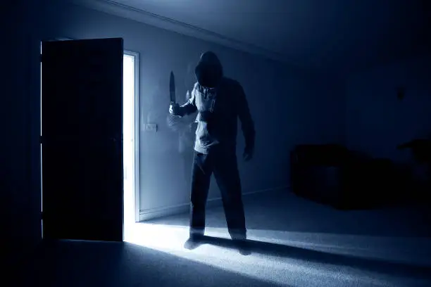 Burglar breaking into a house and threatening with a knife