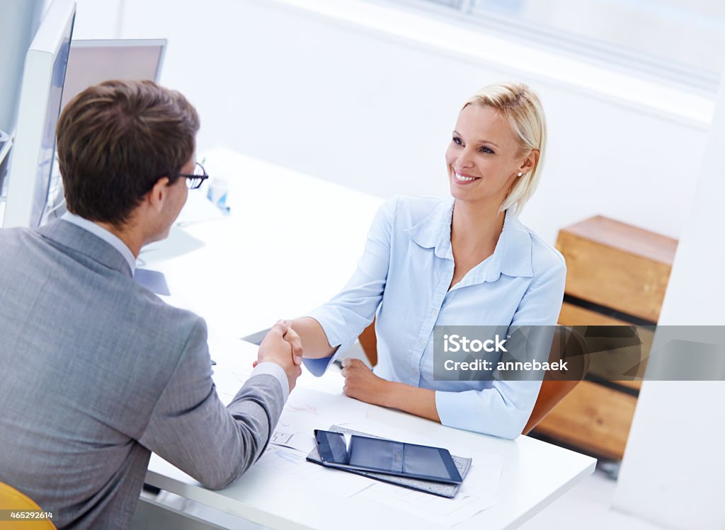 Congratulations, you're top of the team! Shot of a positive businesswoman shaking hands with a male staff member Handshake Stock Photo