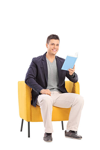 istock Man reading a book seated in an armchair 465293946