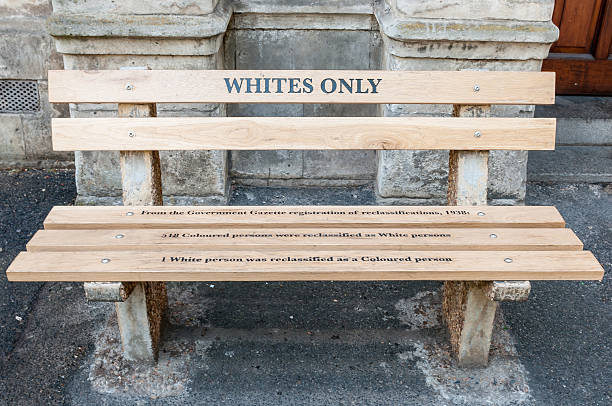 Whites only - reconstructed apartheid bench in Cape Town Cape Town, South Africa - December 18, 2014: Reconstructed apartheid bench in front of the High Court building explaining the race re-classification act of 1938 segregation stock pictures, royalty-free photos & images