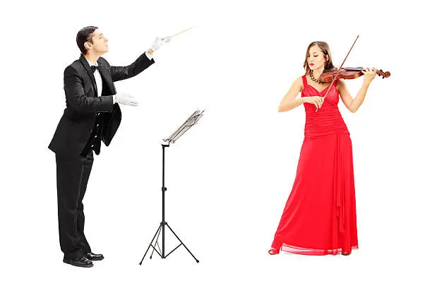 Photo of Male orchestra conductor directing a female playing violin