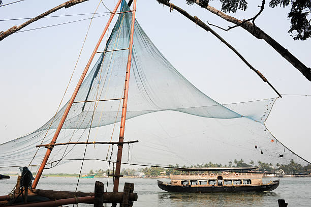 travail des pêcheurs un filet de pêche chinois - kerala harbor malabar coast chinese fishing net photos et images de collection