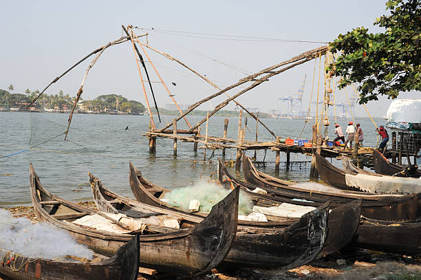 travail des pêcheurs un filet de pêche chinois - kerala harbor malabar coast chinese fishing net photos et images de collection