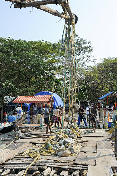 travail des pêcheurs un filet de pêche chinois - kerala harbor malabar coast chinese fishing net photos et images de collection