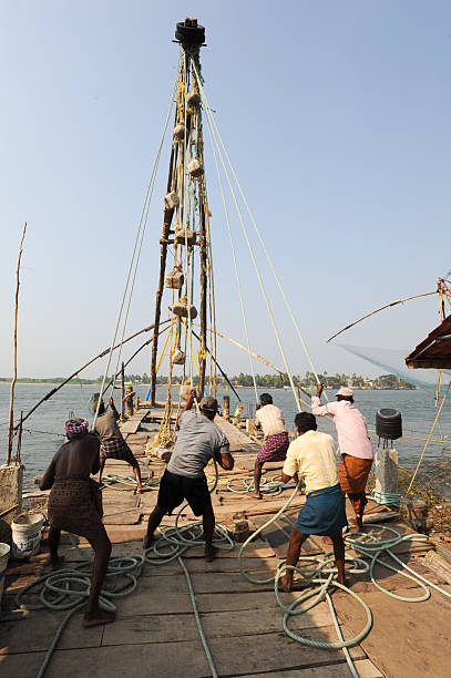 travail des pêcheurs un filet de pêche chinois - kerala harbor malabar coast chinese fishing net photos et images de collection