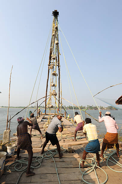 travail des pêcheurs un filet de pêche chinois - kerala harbor malabar coast chinese fishing net photos et images de collection