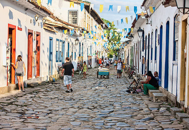 Colonial cobblestone street in Brazilian town of Paraty Paraty, Brazil - November 22, 2012: Colonial cobblestone street in Brazilian town of Paraty. Tourists and locals are pictured on the street paraty brazil stock pictures, royalty-free photos & images