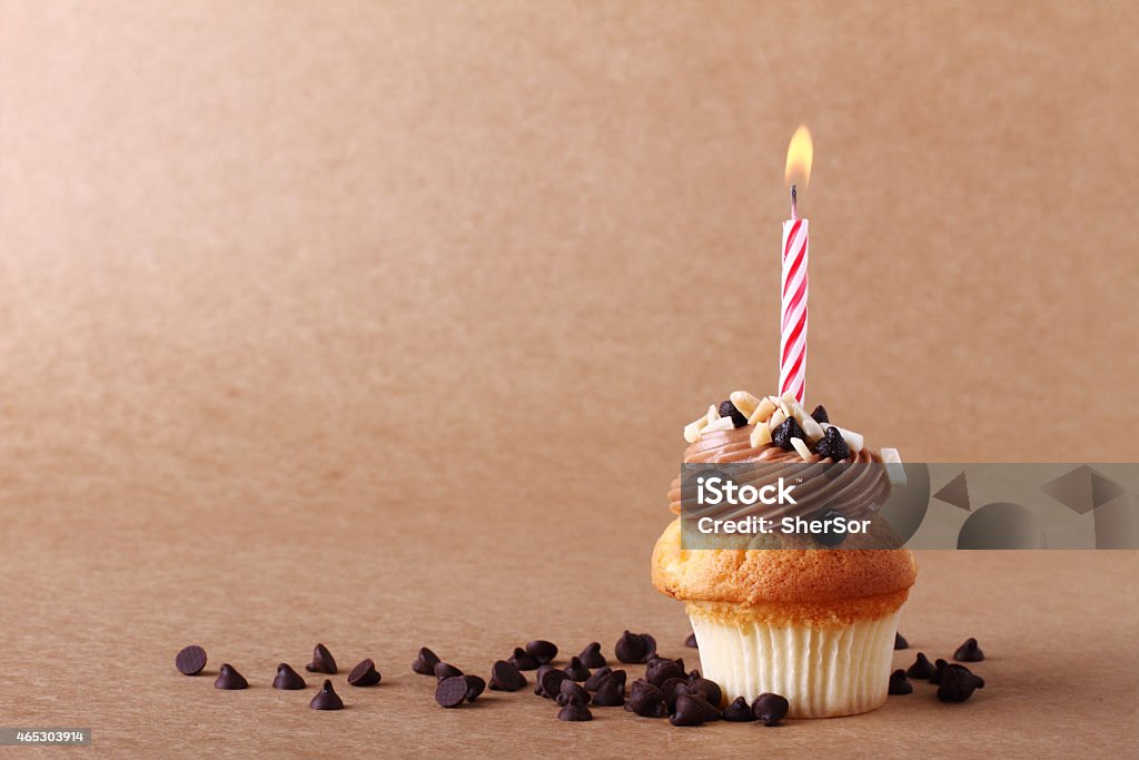 birthday cupcake with candle birthday cupcake with candle on chocolate background Baked Pastry Item Stock Photo