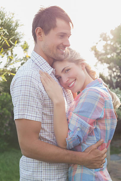 istock Smiling couple embracing in the park 465317580
