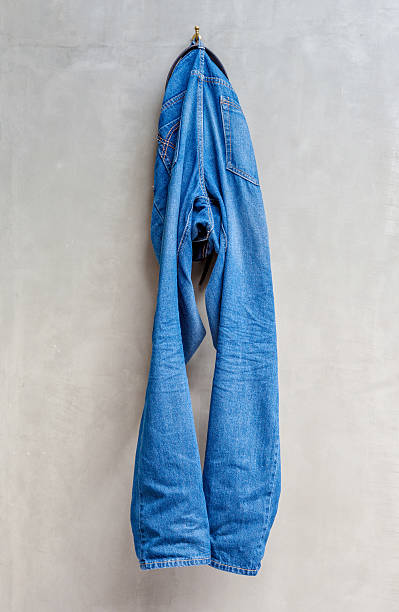 istock Hanging the blue jeans draped on exposed concrete wall. 465317908