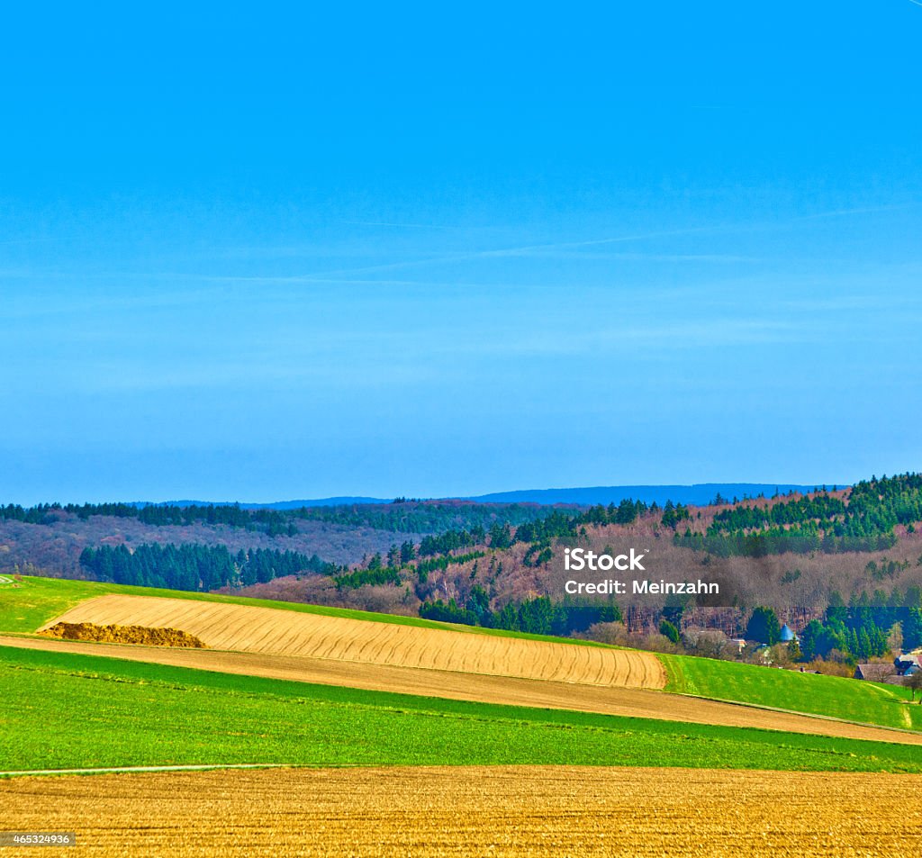 landscape with fields and a village with hills landscape with fields and a village with hills at the horizon 2015 Stock Photo